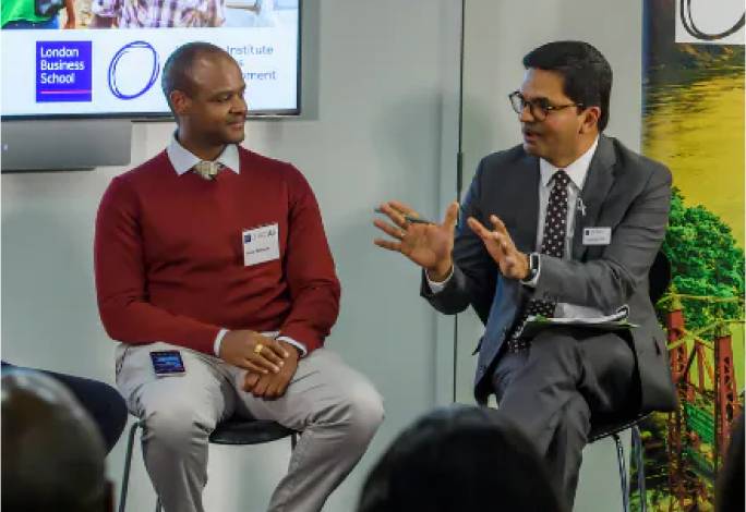 Faculty members in conversation on stage