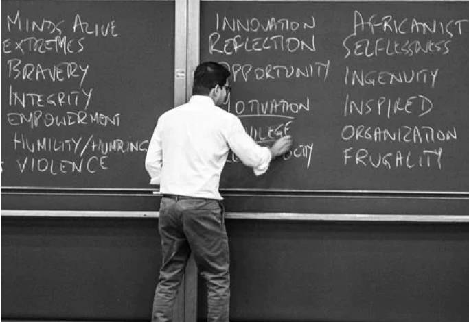 A man writing on a chalkboard