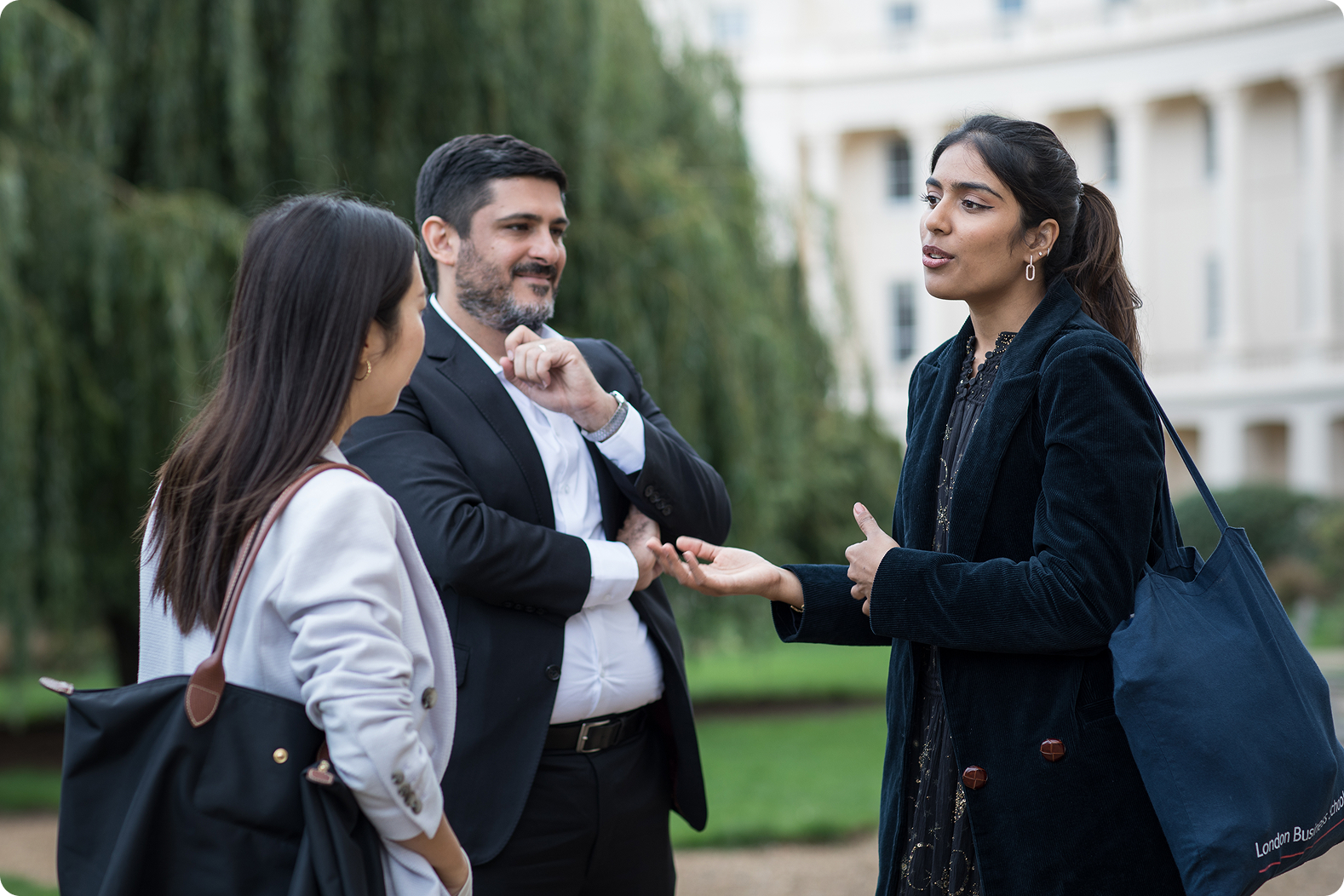 Three students conversing on campus