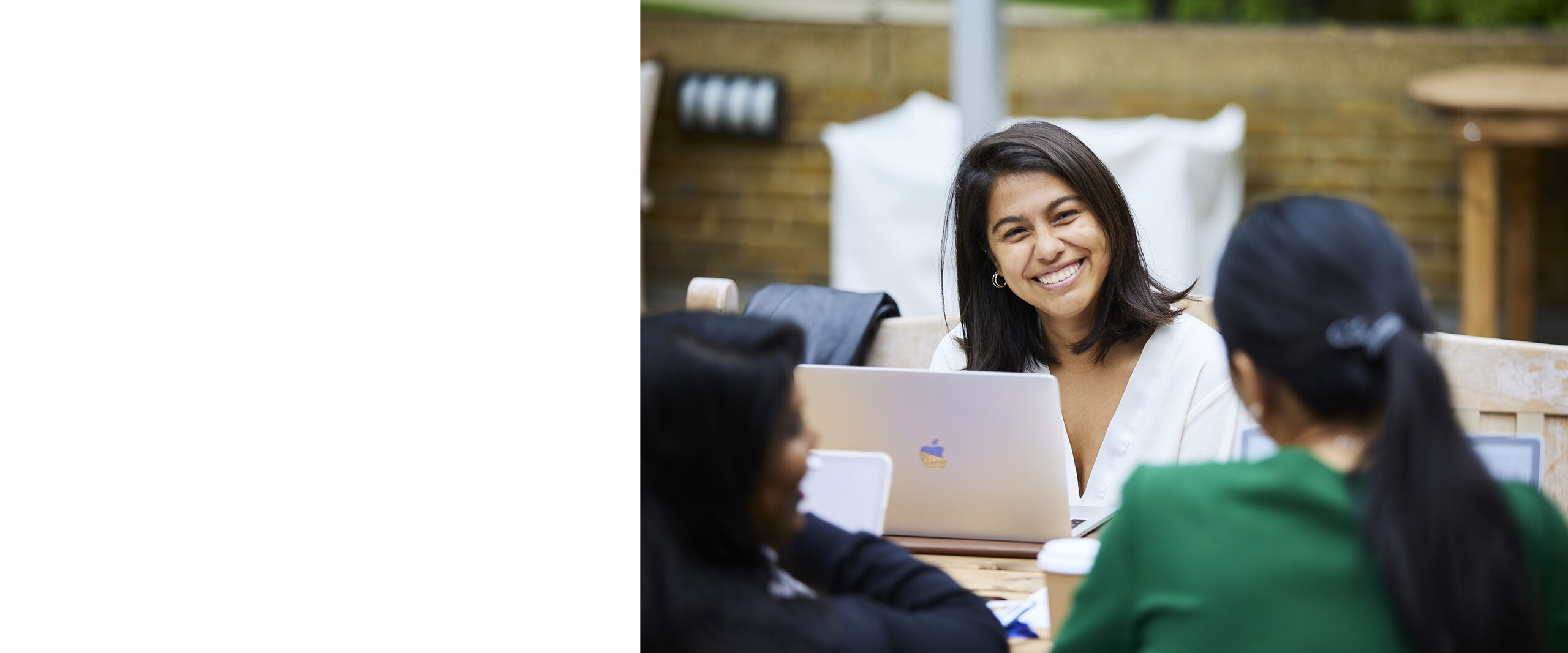 Smiling lady sat at a table on her laptop
